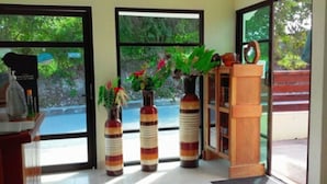 A reception area with a desk, two striped vases with plants, and a wooden cabinet. - Hotel Maya Balam (Calakmul)