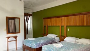 A room with two single beds, a wooden headboard, a small table, and a mirror on the wall. - Hotel Maya Balam (Calakmul)