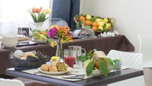 A breakfast buffet with various fruits, pastries, and beverages. - Hotel Le Muse (Syracuse)