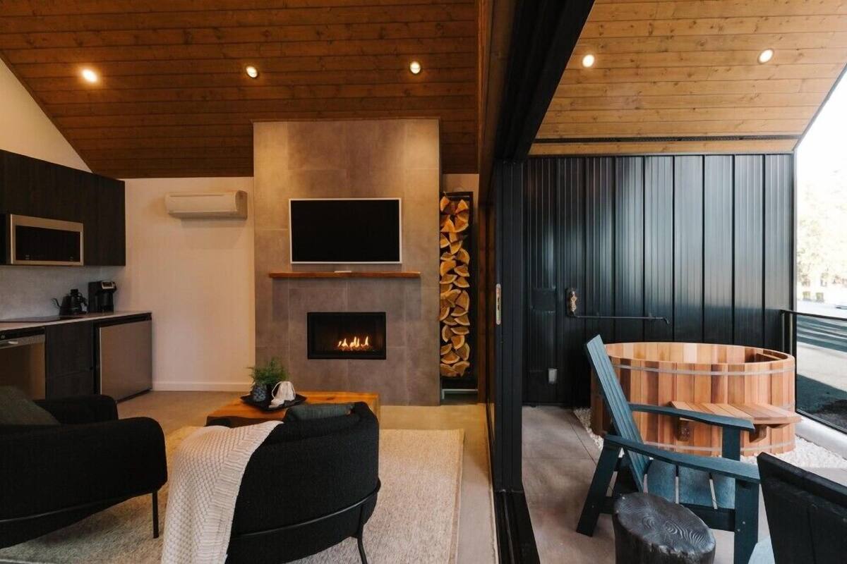 A modern living room with a fireplace, a television, and a wooden sauna.
