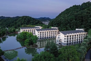 A hotel with multiple buildings, a lake, and surrounding greenery. - Tianmushan Hotspring Hotel (Yichun)