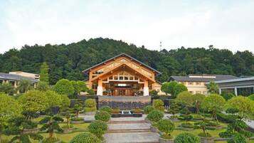 A building with a traditional architectural style, surrounded by well-maintained gardens and pathways.