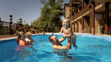 Relax by the pool surrounded by lush greenery and comfortable seating.