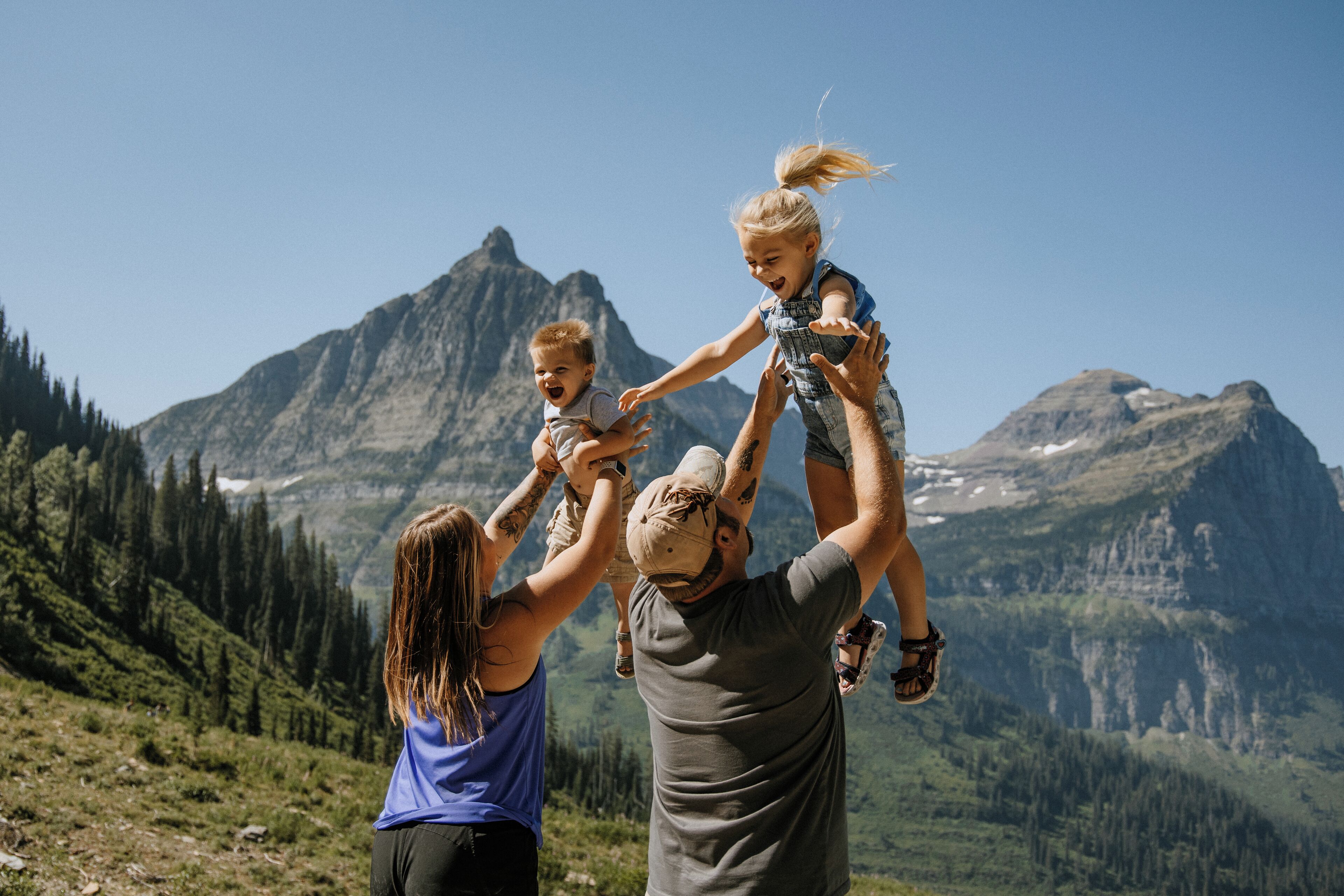 A family playing on a mountain with a clear view of the surrounding landscape.