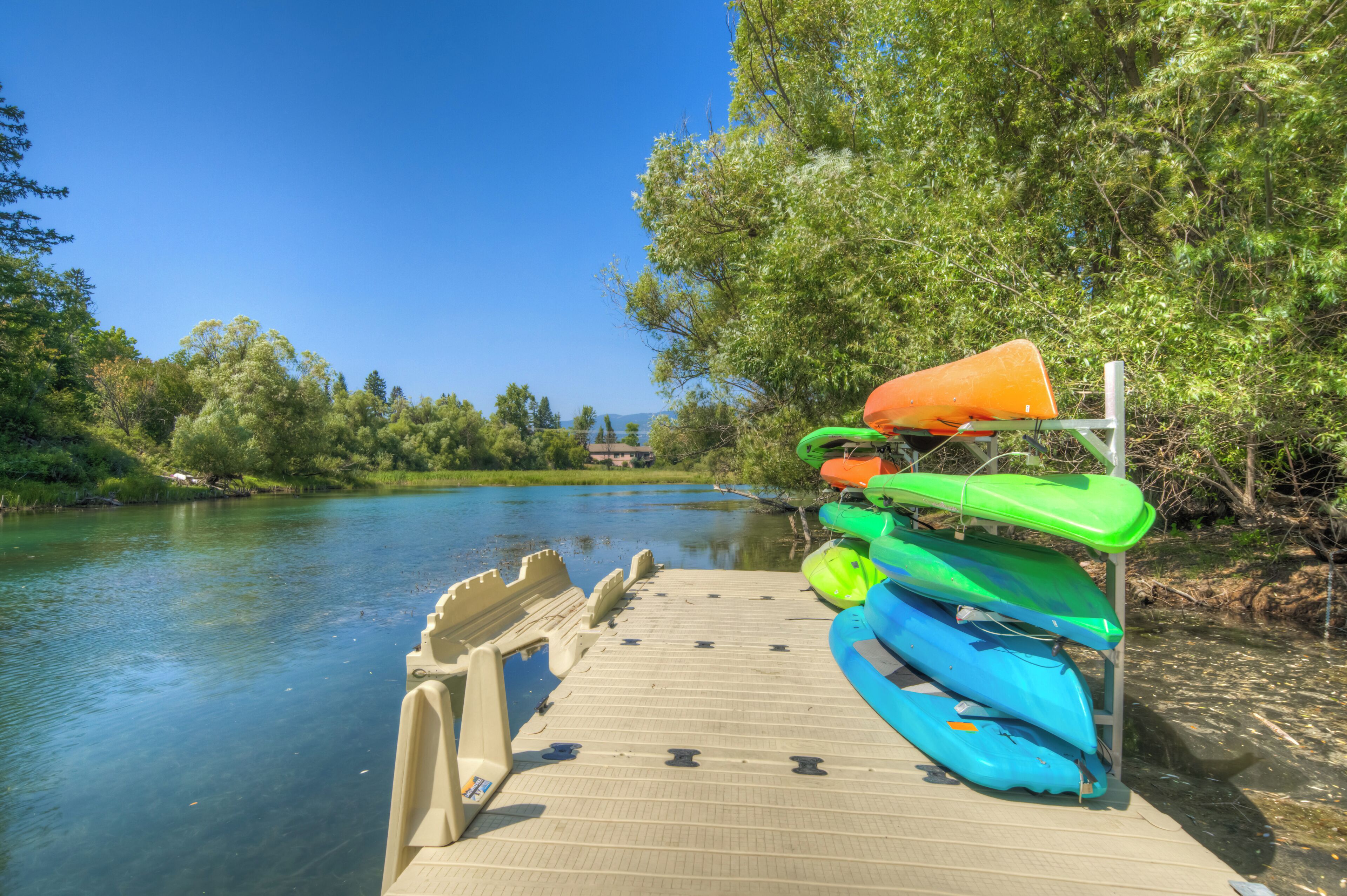 Eine Holzsteg mit Kajaks und einem Stand-Up-Paddleboard.