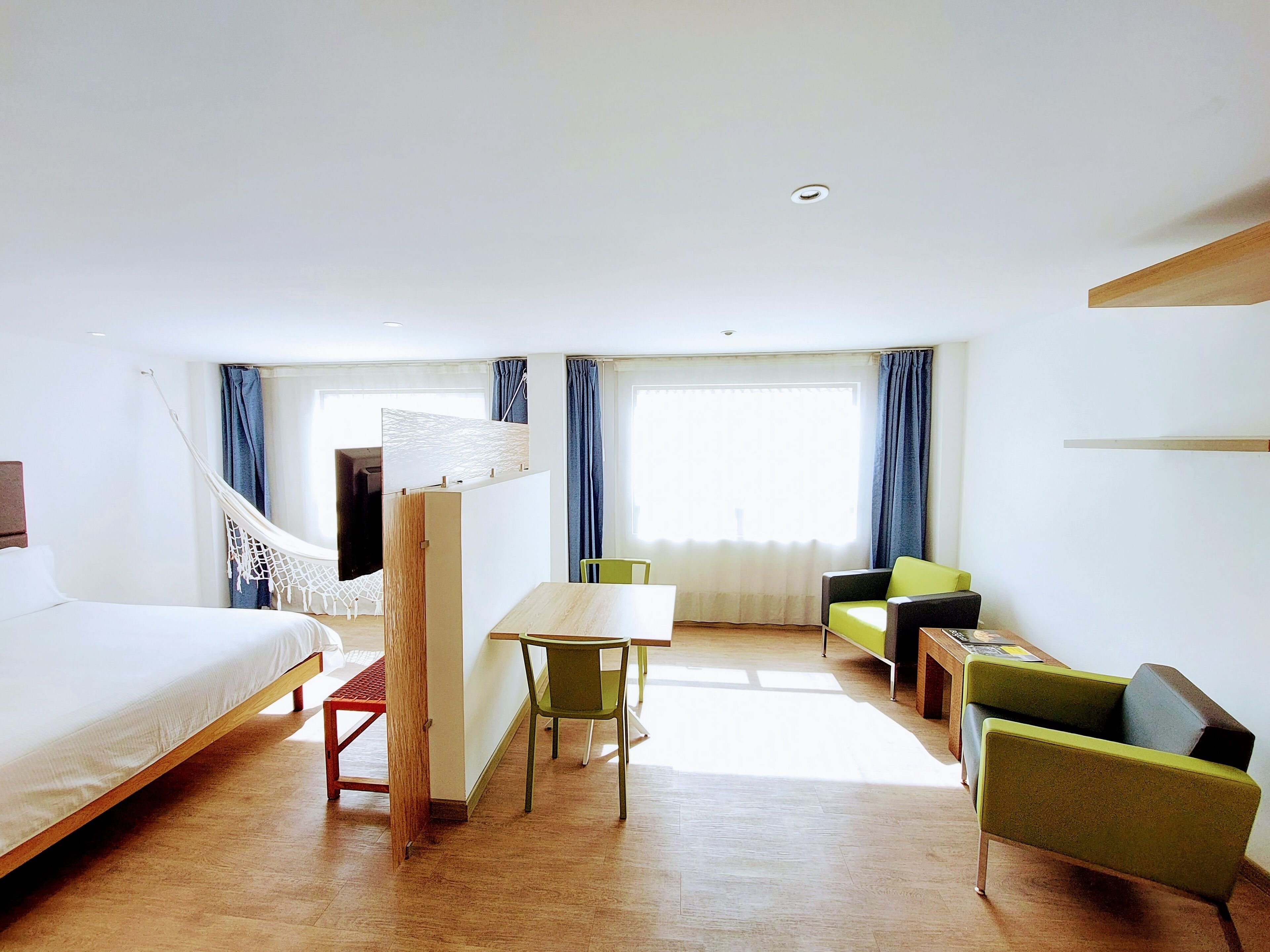 Une chambre d’hôtel avec un lit, un bureau, une chaise et un canapé.