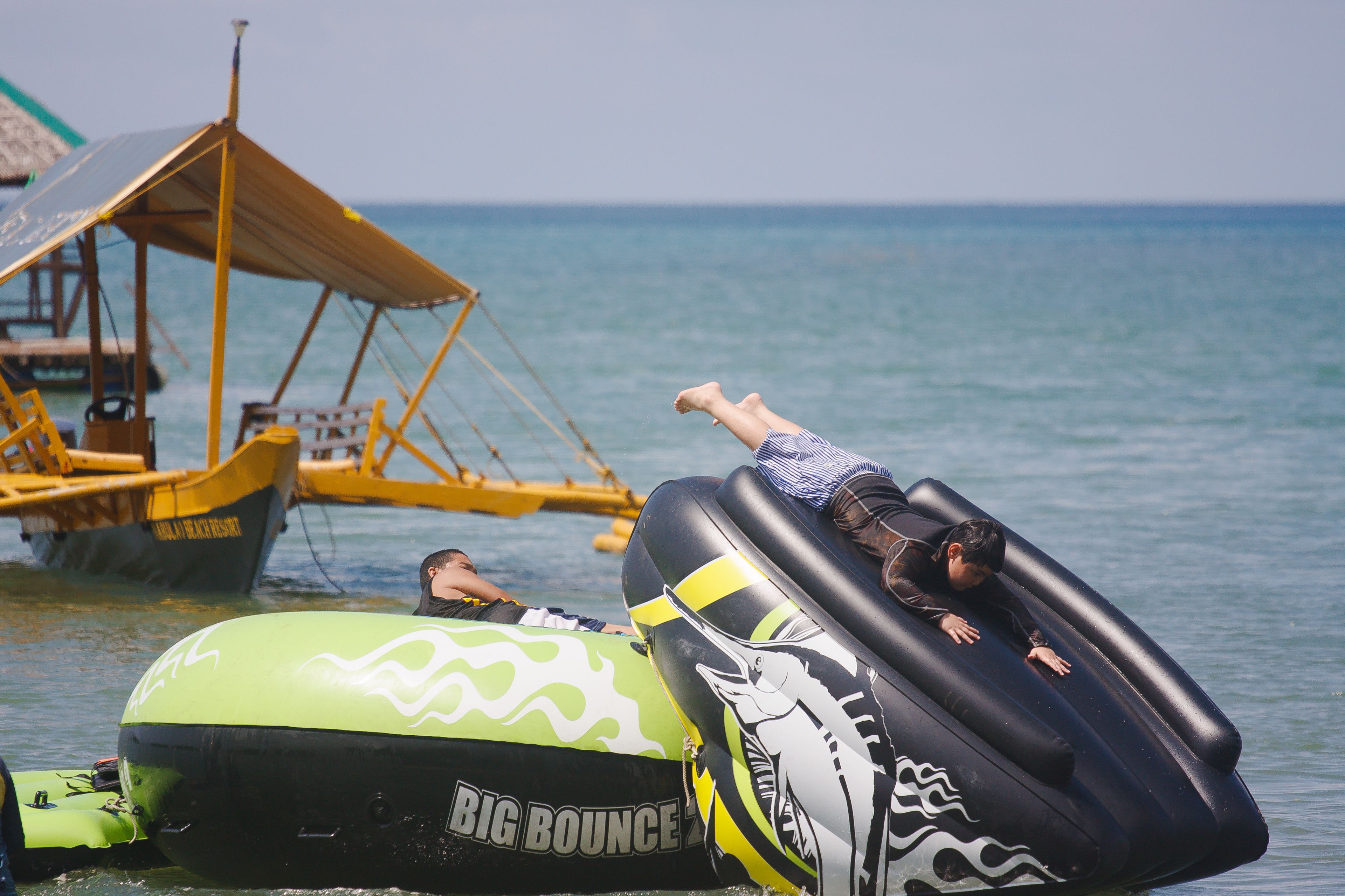 Inflatable tubes on the water with a boat and a dock in the background.