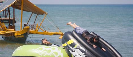 Inflatable tubes on the water with a boat and a dock in the background.
