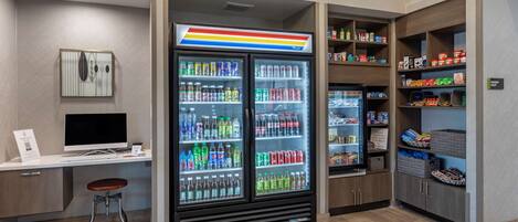 A modern kitchenette with a refrigerator, a microwave, and a sink.