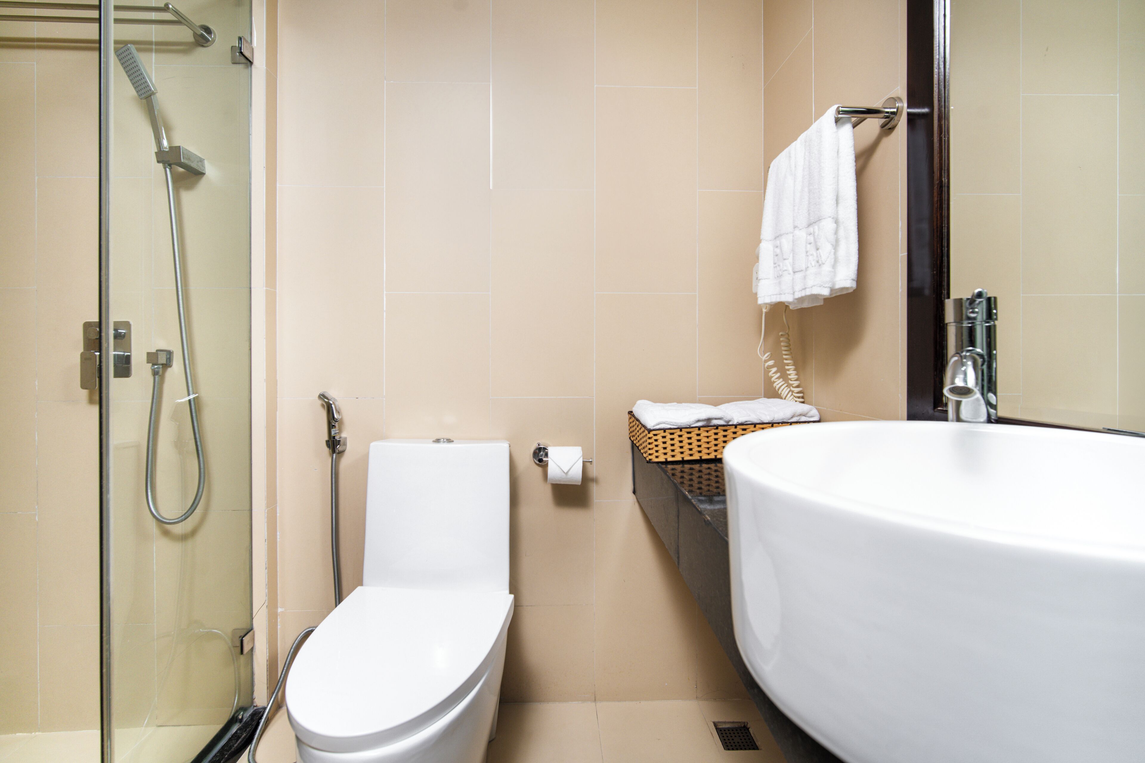 A bathroom with a glass-enclosed shower, a toilet, and a large bathtub.