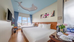 A hotel room with a large bed, a flat-screen TV, a city view, and a breakfast bar with water bottles. - ANFADA Hotel Danang (Da Nang)
