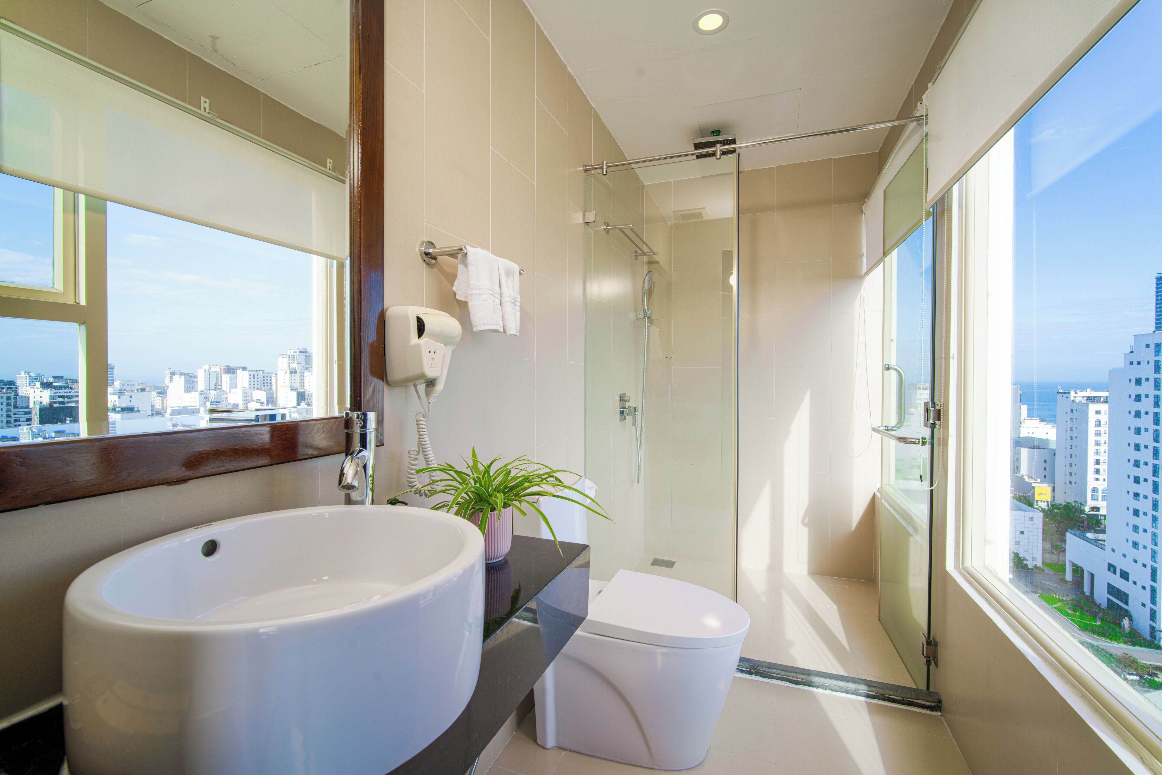 Un baño moderno con un lavamanos grande, inodoro y cabina de ducha de vidrio.