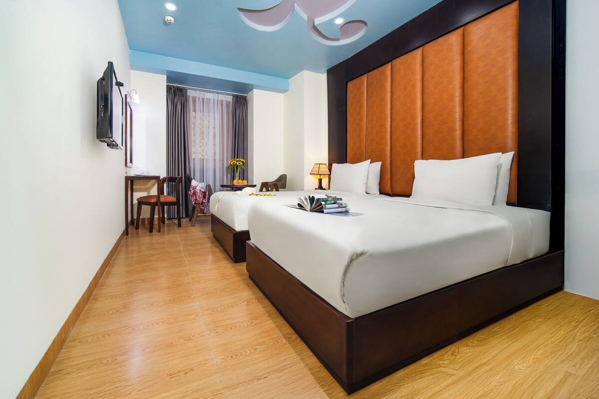 A hotel room with a large bed, a desk, and a television.