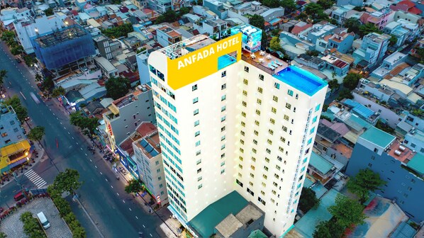 A high-rise hotel with multiple floors, a rooftop pool, and a prominent sign.