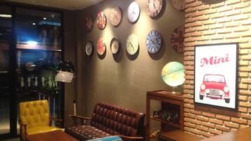 A room with a brick wall, multiple clocks, a sofa, a table, and a globe.