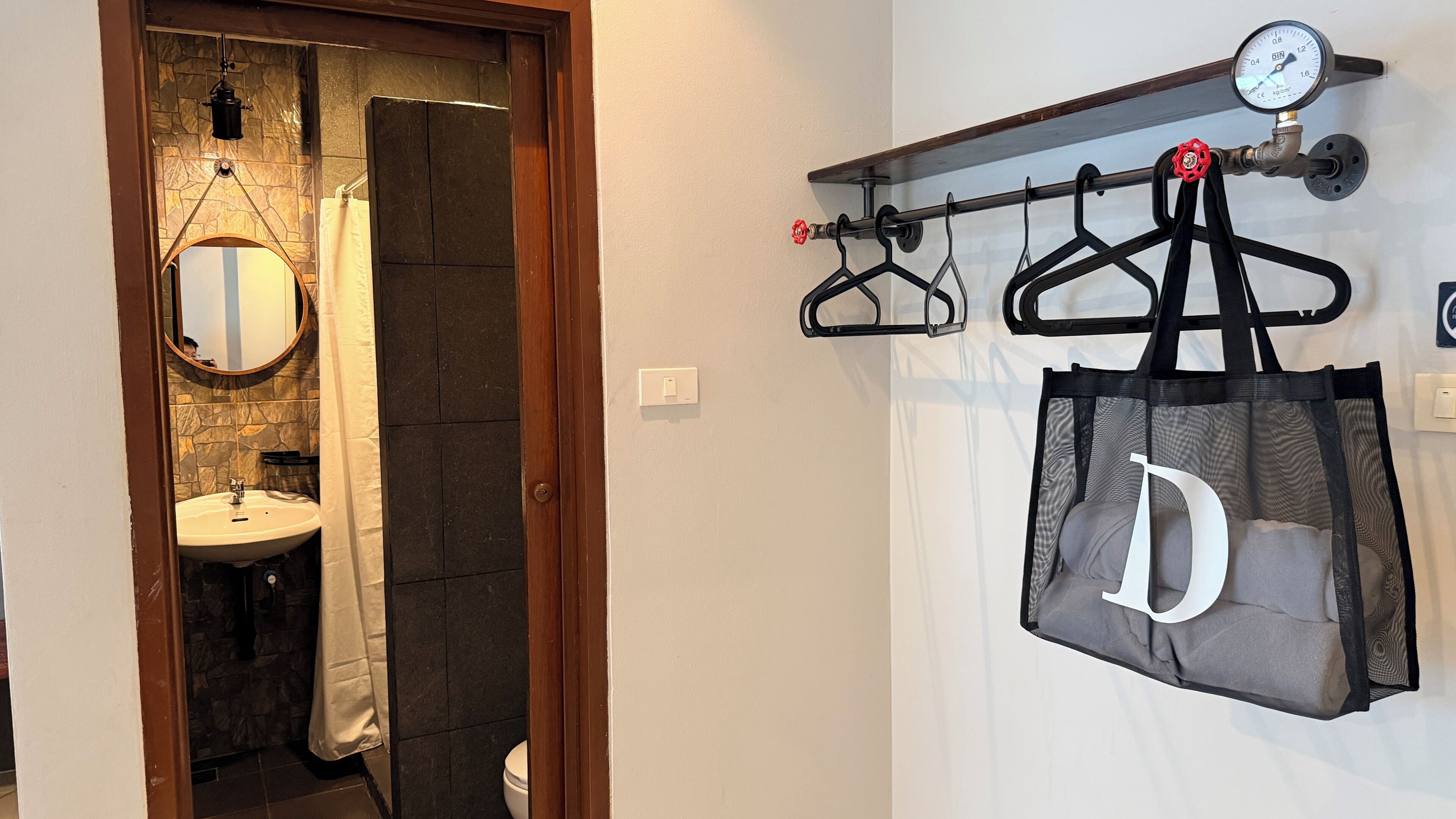 Ein Badezimmer mit Steinwand, Spiegel, Waschbecken und Duschvorhang.