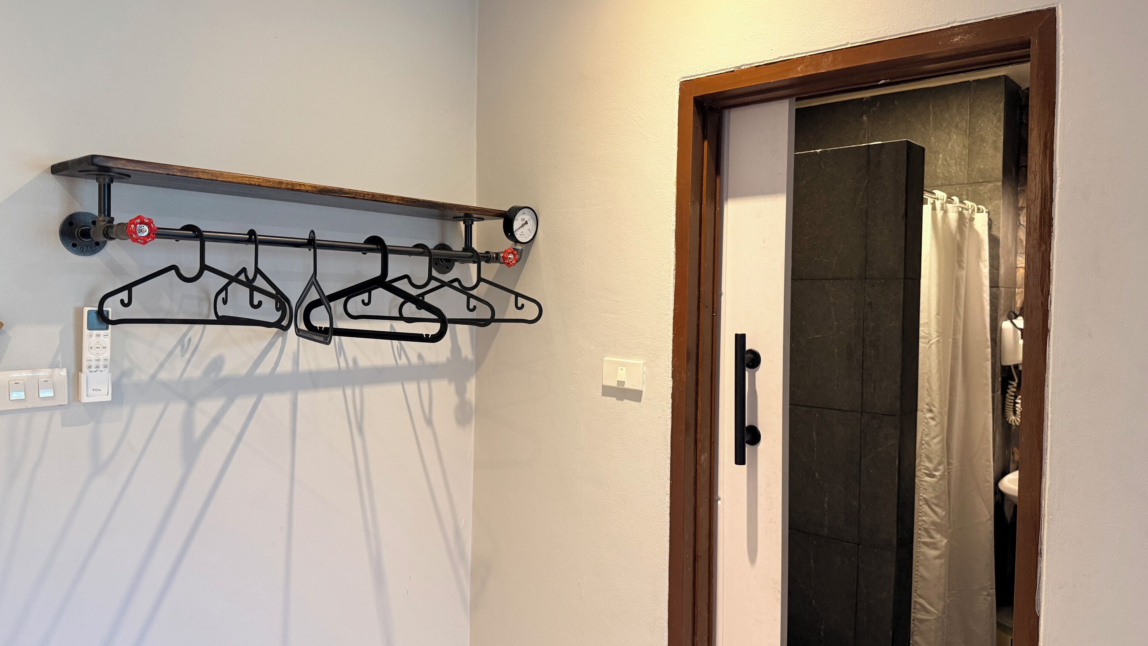 Un étendoir mural doté de plusieurs supports et d’un thermostat.