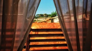 Un escalier en bois mène à une terrasse d’où l’on peut admirer un bâtiment et des arbres.