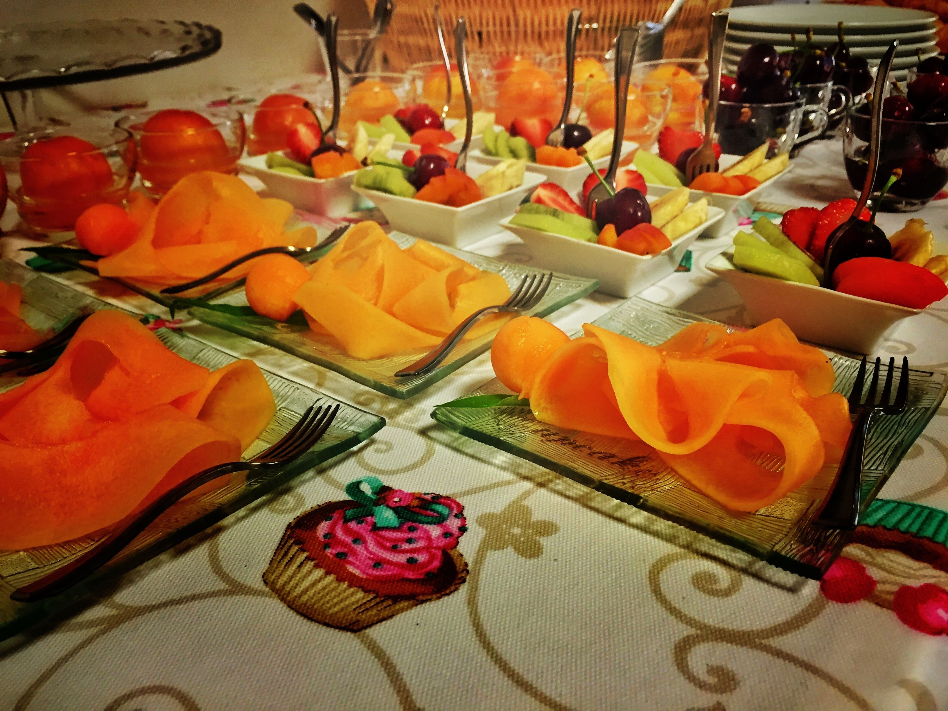 Une table de buffet avec divers fruits et un cupcake.