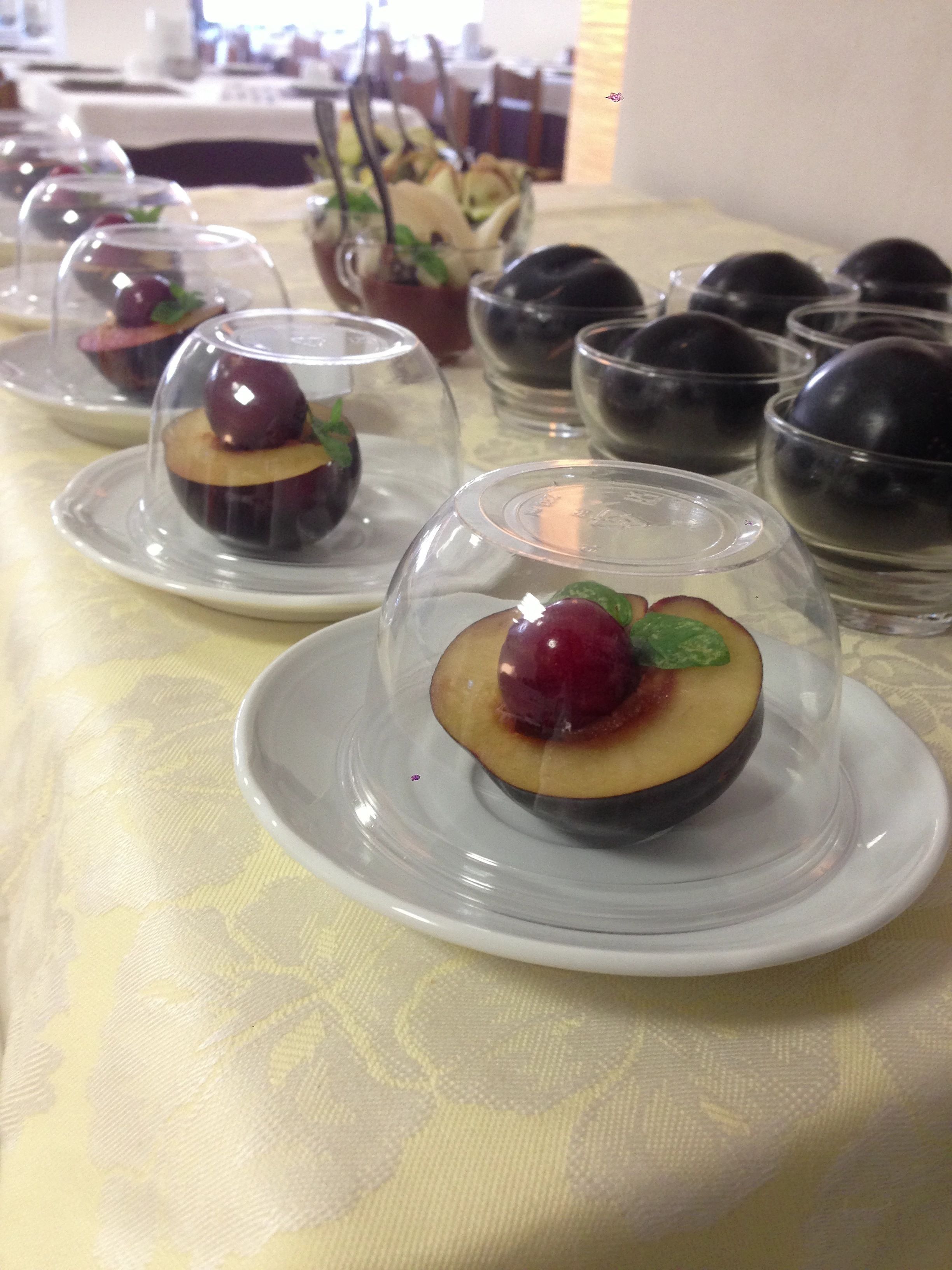 Una mesa con cúpulas de cristal transparente que contienen alimentos, probablemente para un bufé o un evento.