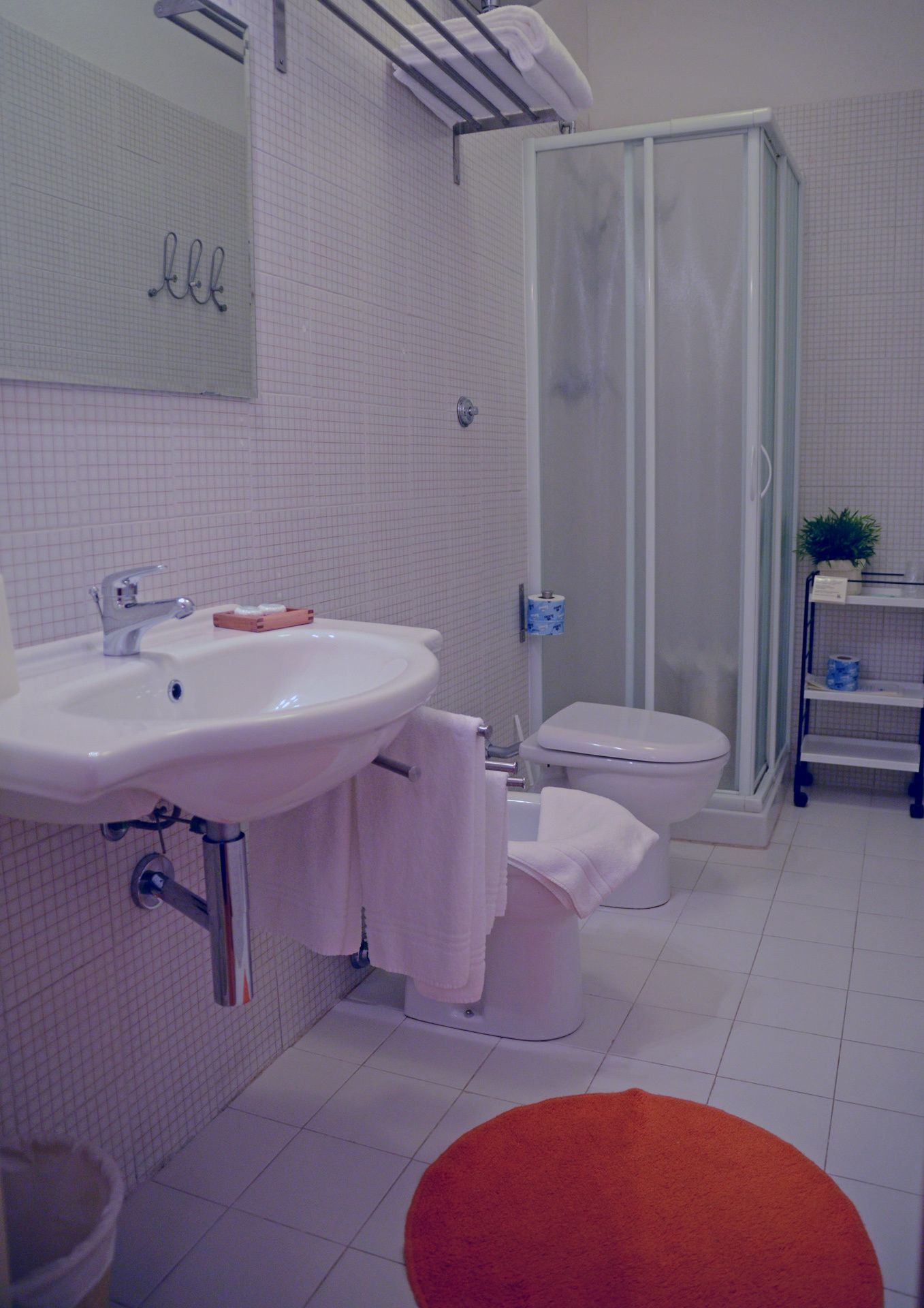 A bathroom with a sink, toilet, and shower.