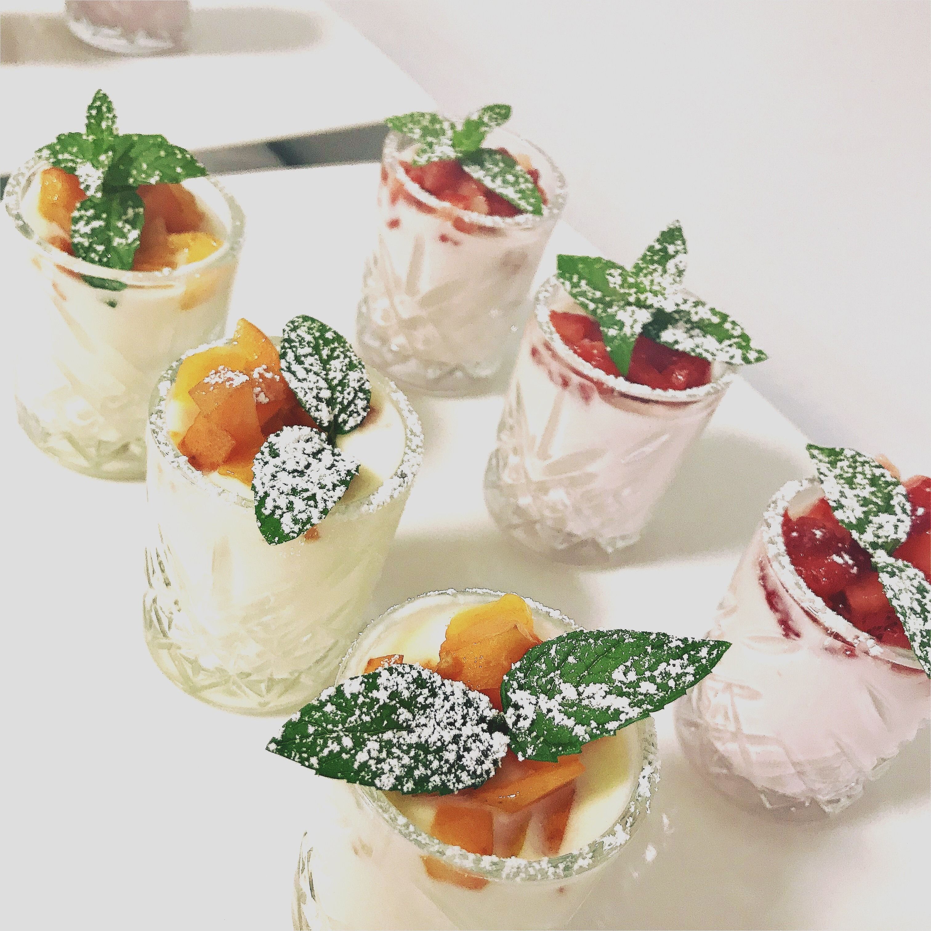 Vasos de postre con fruta y hojas de menta.