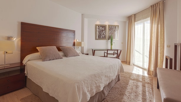 A hotel room with a large bed, bedside tables, a desk, and a chair. - Can Salia (Sant Josep de sa Talaia)