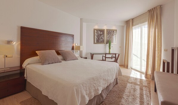 A hotel room with a large bed, bedside tables, a desk, and a chair. - Can Salia (Sant Josep de sa Talaia)
