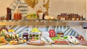 A buffet with various food items including fruits, cheeses, meats, and condiments. - Can Salia (Sant Josep de sa Talaia)