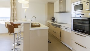 A modern kitchen with a central island, bar stools, a Bosch microwave, and a coffee maker. - Can Salia (Sant Josep de sa Talaia)