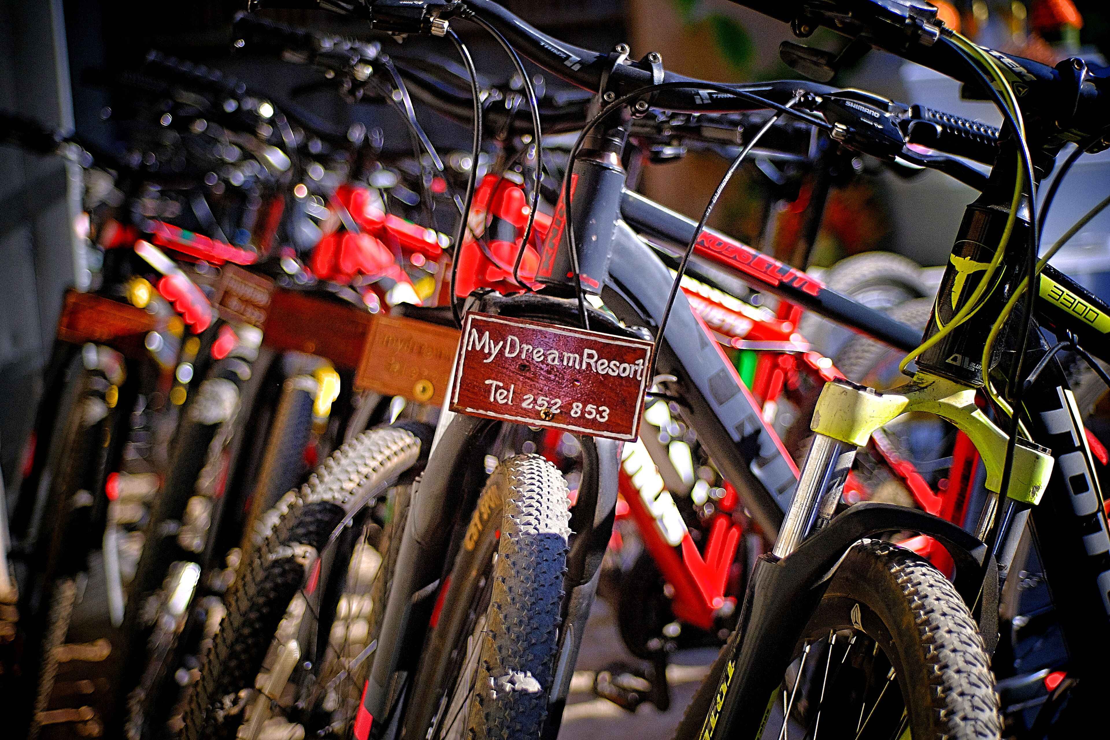 Una hilera de bicicletas con un cartel que dice "My Dream Resort Tel 252 853".