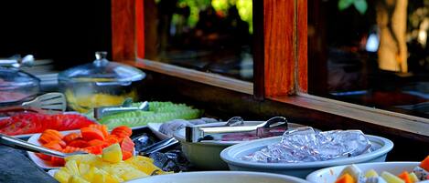 A buffet with various food items and utensils.