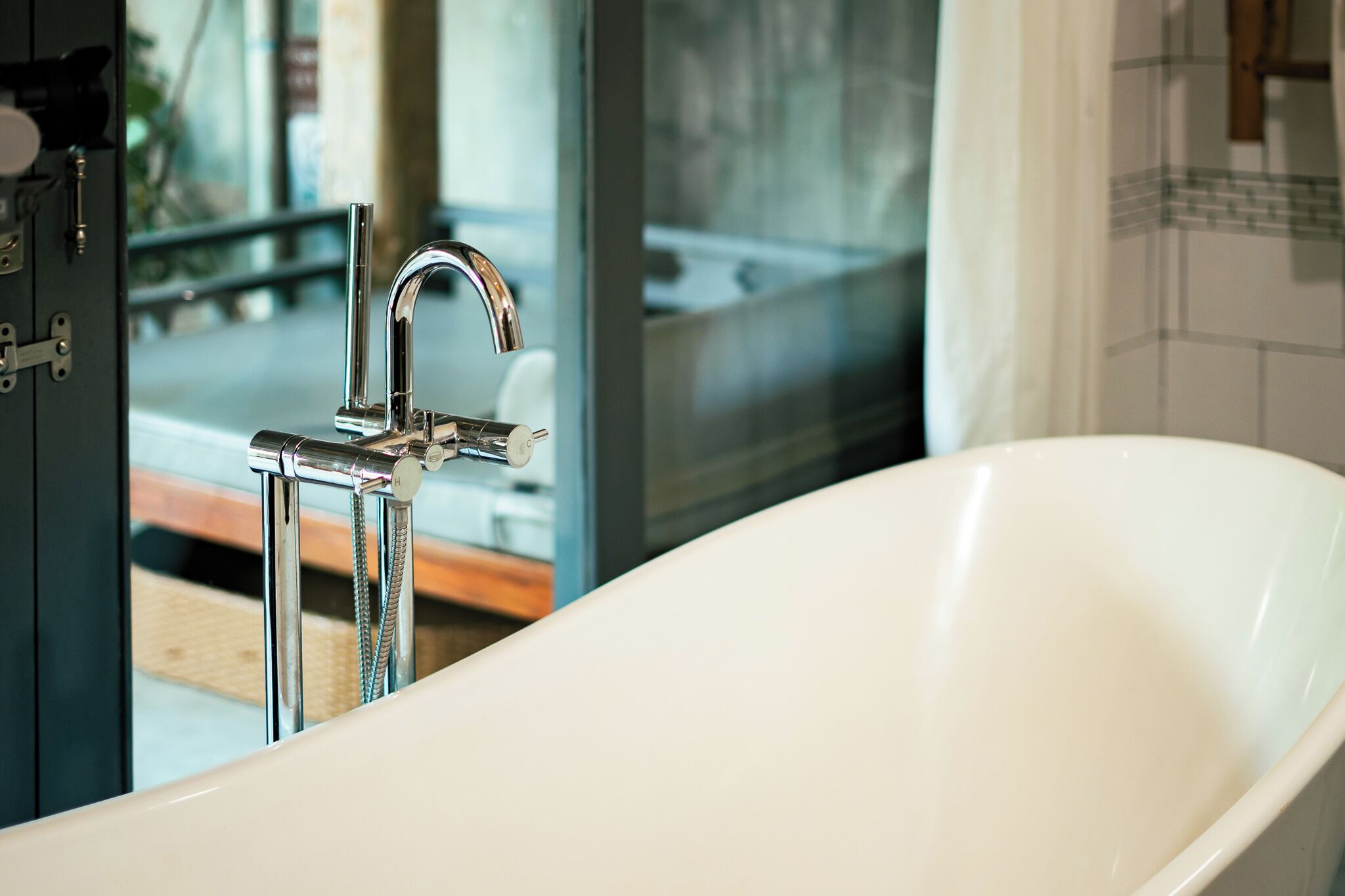 Un bagno moderno con una vasca freestanding, un rubinetto cromato e un box doccia in vetro.