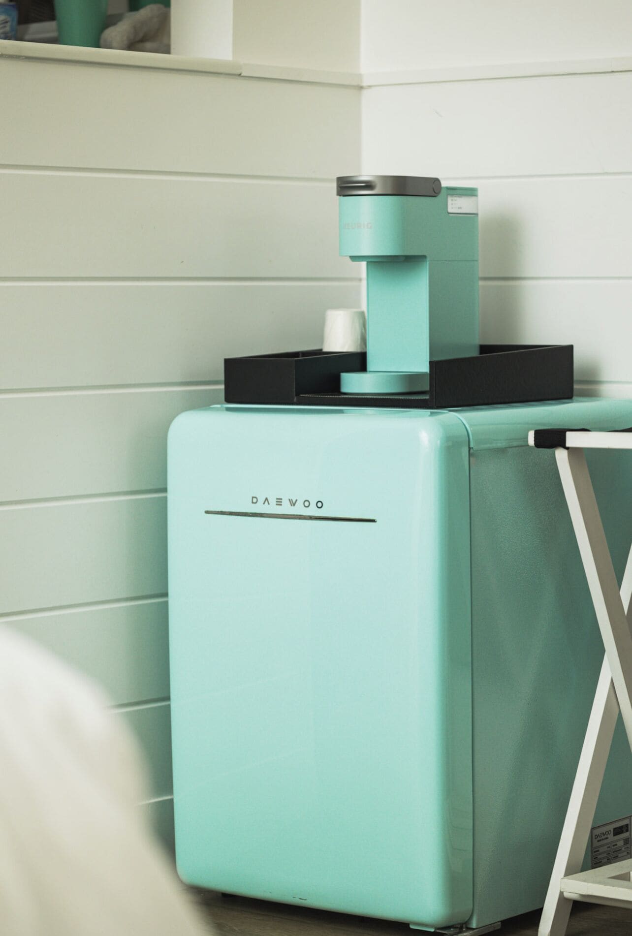 Ein türkisfarbener Kühlschrank von Daewoo in einer Küche mit weißen Schränken.