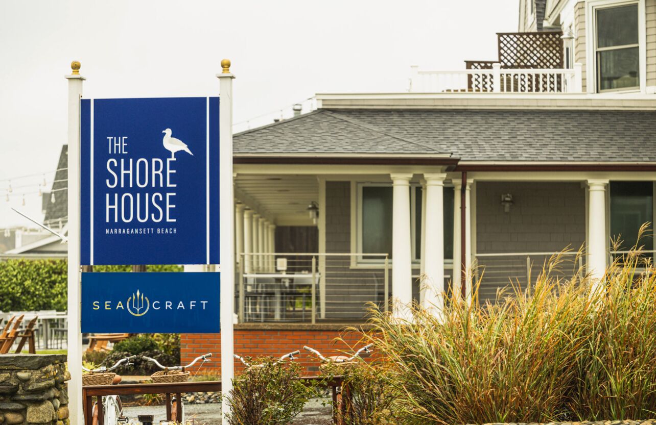 A building with a sign for "The Shore House" and "SeaCraft" on the beach.