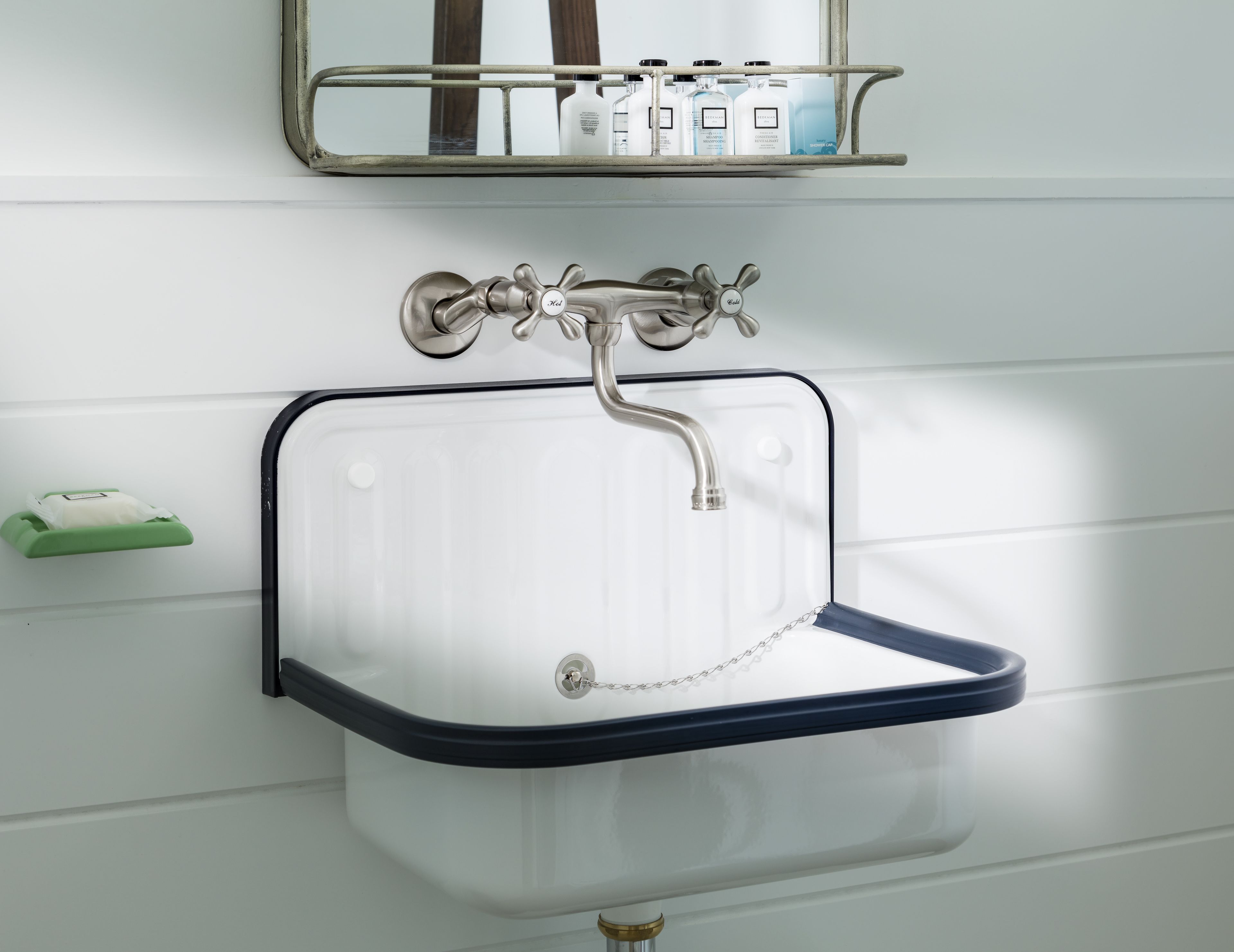 A bathroom with a white sink, a chrome faucet, and a mirror above it.