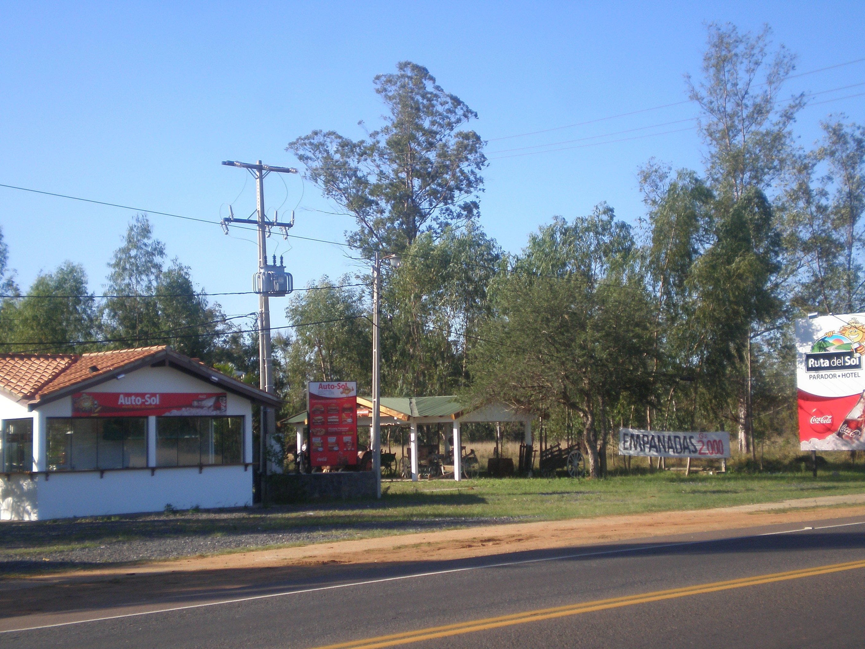 A small building with a red roof and a sign that reads "Auto-Sol".