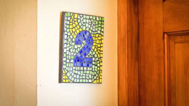 A mosaic artwork with a prominent number '2' on a wall.