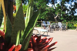 A patio area with a table and chairs, surrounded by greenery. - Villa Coral (Vieques)