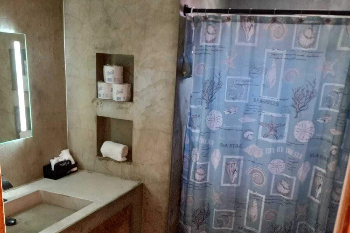 A bathroom with a sink, toilet, and shower curtain.