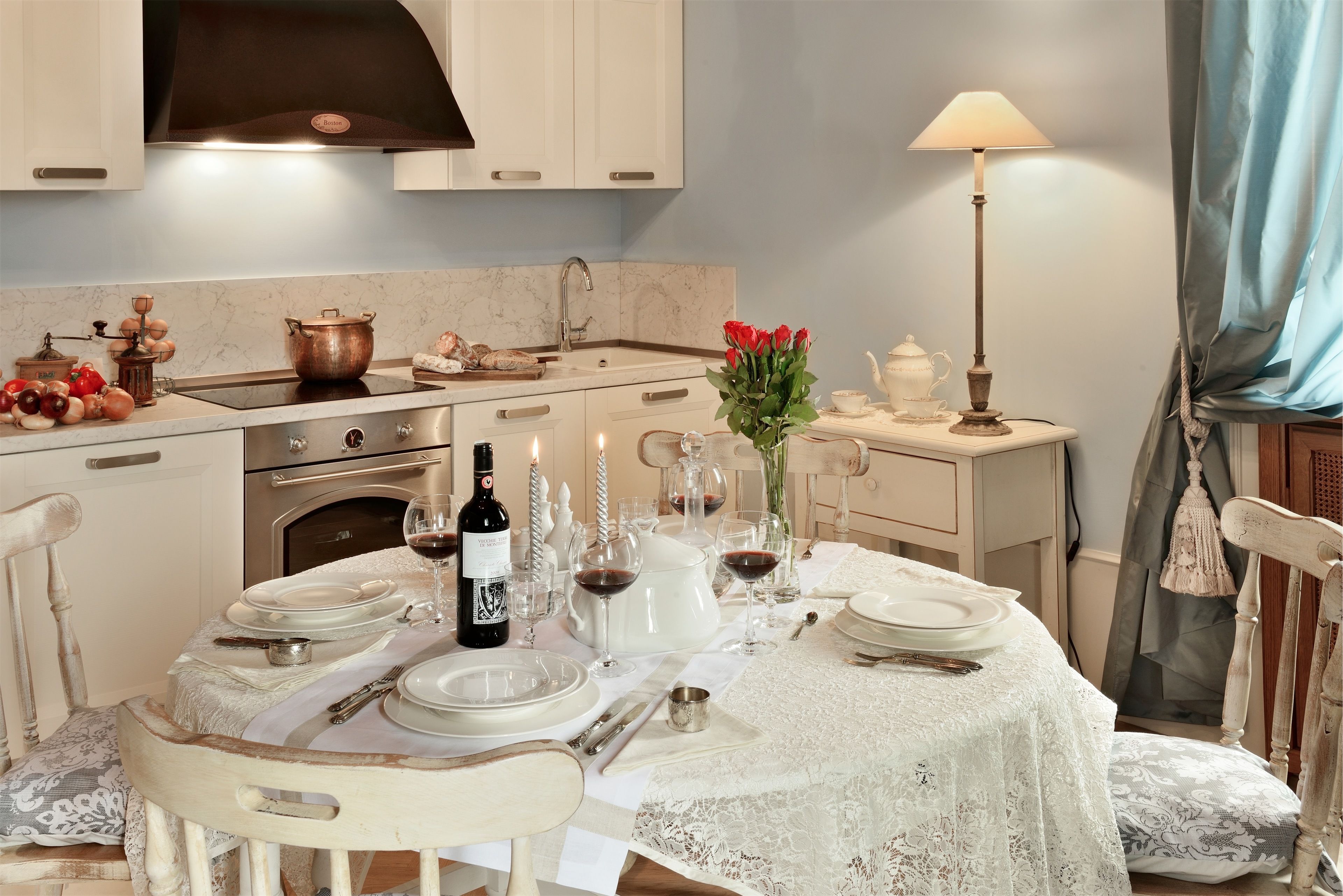 A dining area with a table set for four, a stove, and a sink.