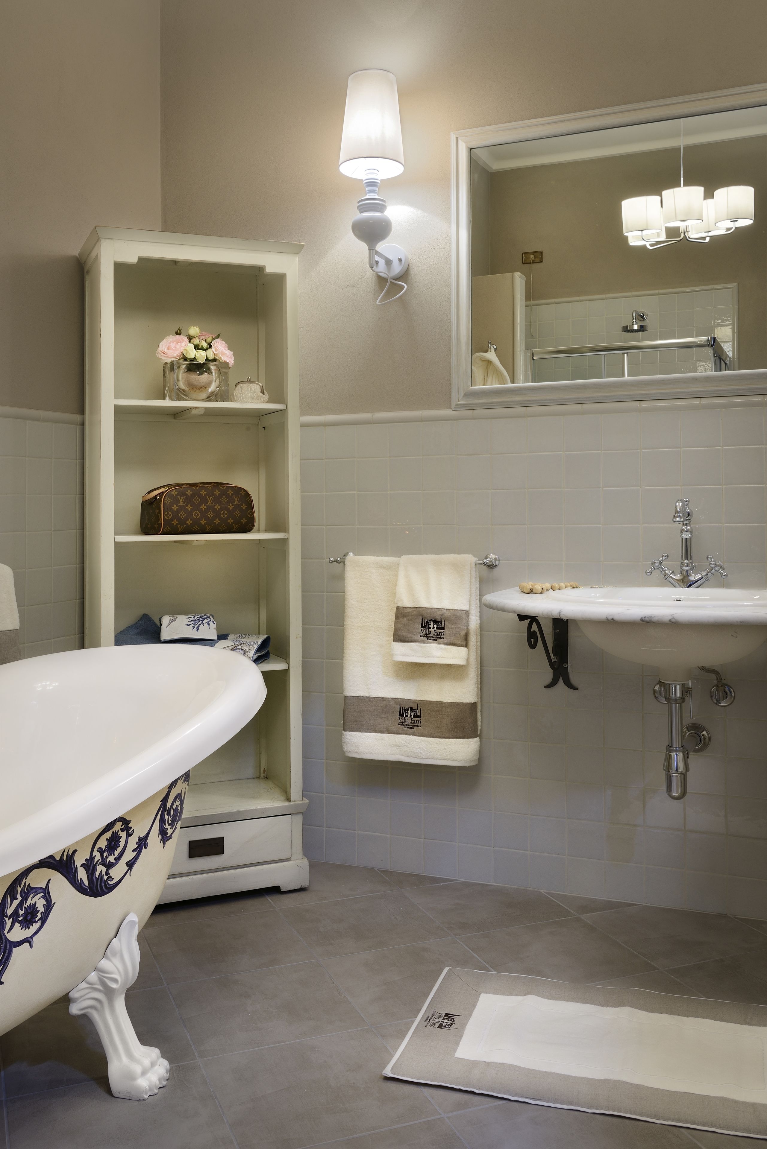 Une salle de bain avec une baignoire sur pieds, un meuble-lavabo avec un miroir et un porte-serviettes.