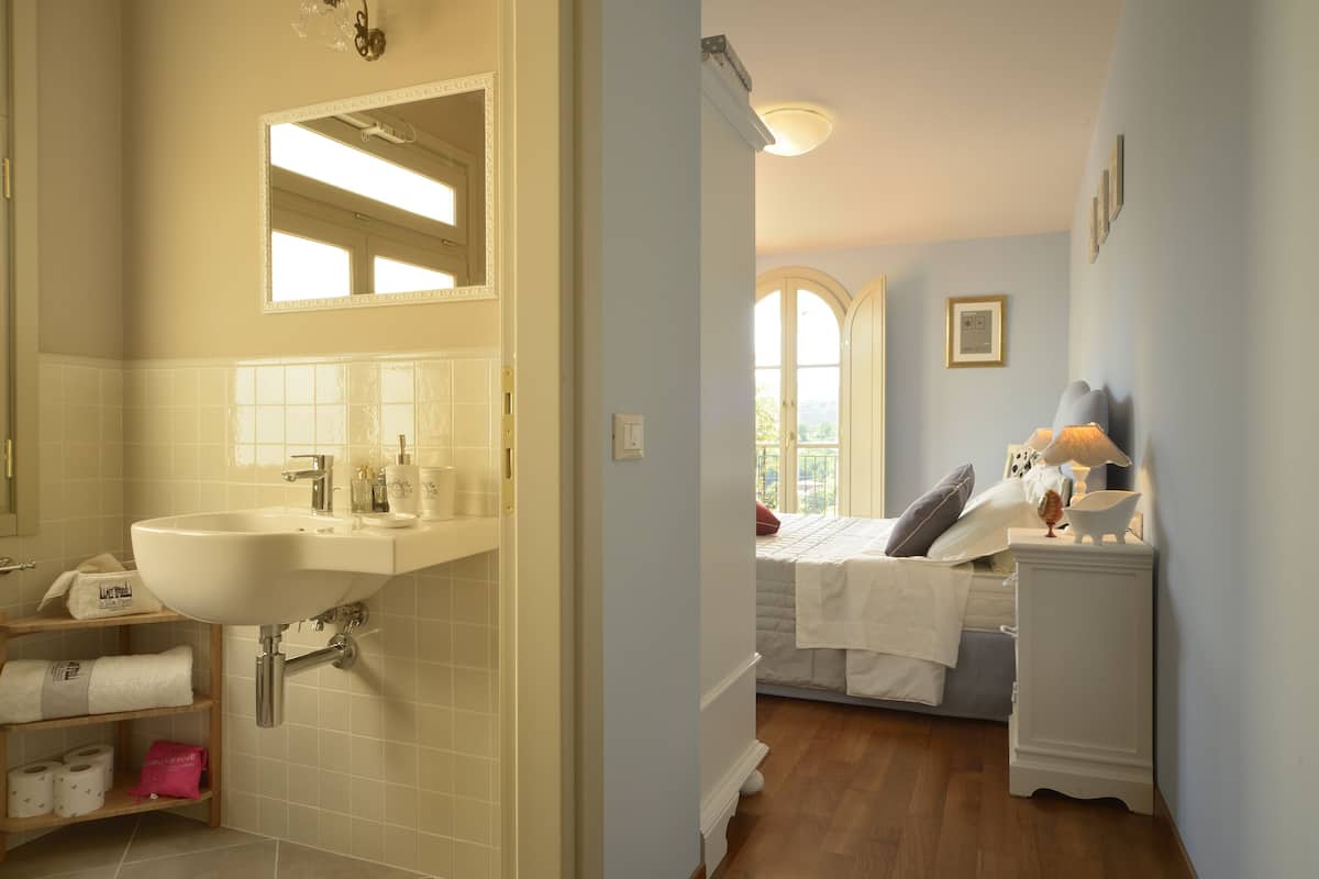 A bathroom with a sink, mirror, and shelves with towels.