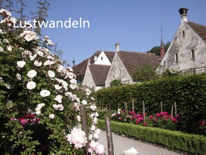 A traditional European building with a stone facade, surrounded by well-maintained gardens with blooming flowers. - Stiftung Kartause Ittingen (Warth-Weiningen)