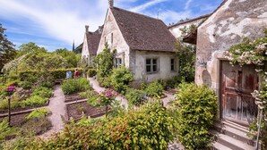 A traditional European village with stone houses, a garden with various plants and flowers, and a clear blue sky. - Stiftung Kartause Ittingen (Warth-Weiningen)