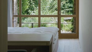 A bedroom with a large window, a bed, and a view of greenery outside. - Stiftung Kartause Ittingen (Warth-Weiningen)
