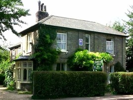 Um edifício de dois andares com uma placa indicando 'Fairlight Lodge' e 'The Retreat'.