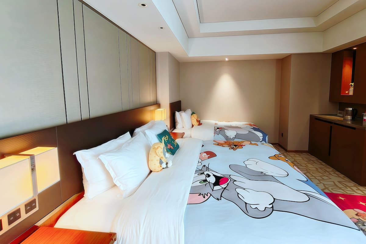 Ein Hotelzimmer mit einem großen Bett, einem Schreibtisch und einer Küchenzeile.