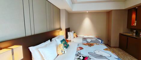 A hotel room with a large bed, a desk, and a kitchenette.