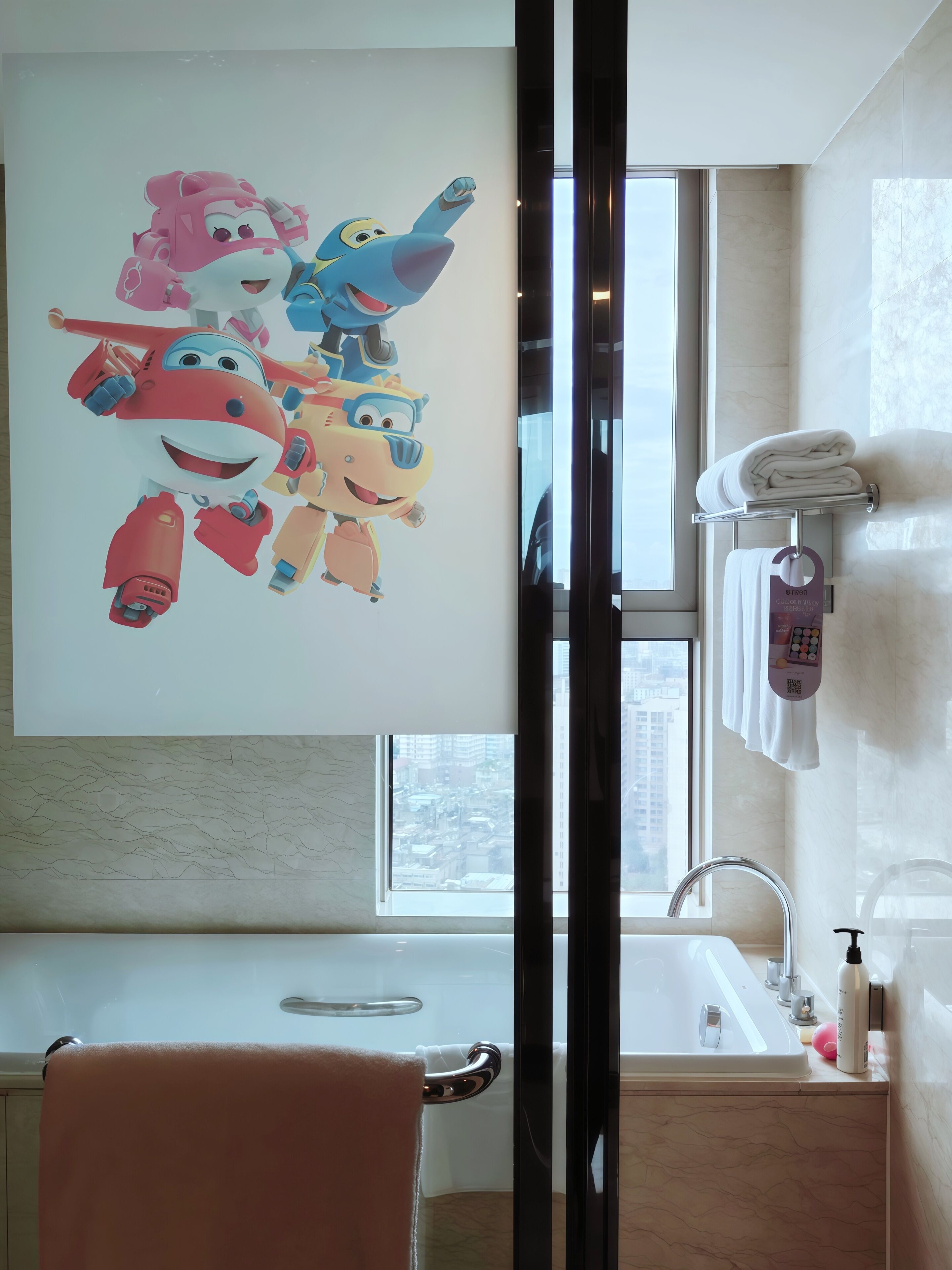 A modern bathroom with a large window, a sink, and a towel rack.